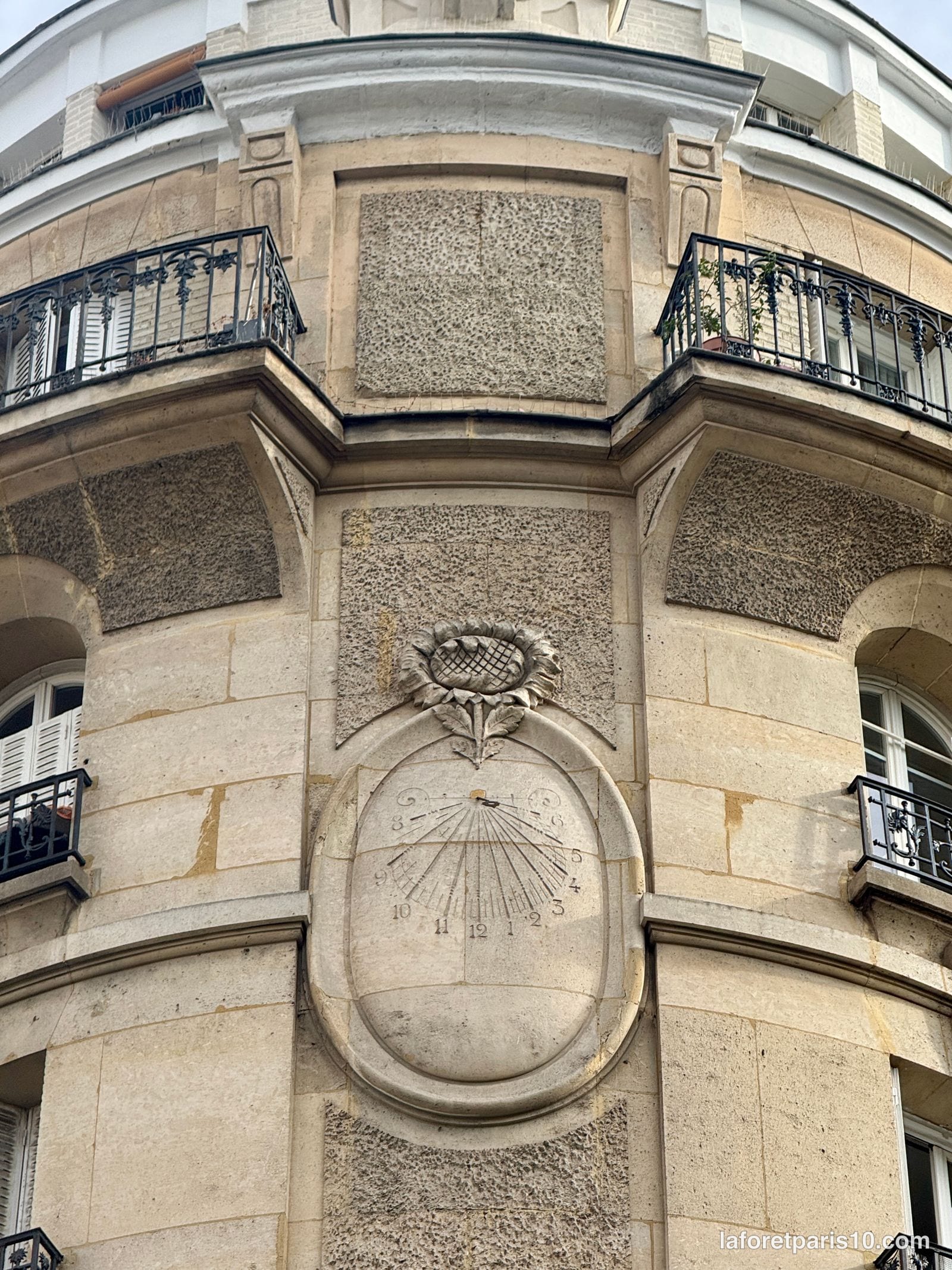 Cadran solaire sculpté dans un médaillon de pierre sur la façade du 196 rue Saint-Maur, Paris 10e