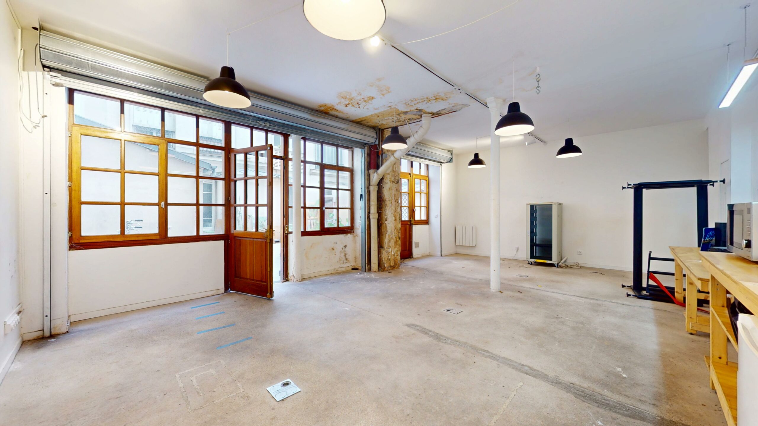 Pièce principale sur cour, menuiseries bois vitrées et suspensions industrielles — local commercial 44 m² à louer, rue du Faubourg Saint-Martin, Paris 10e