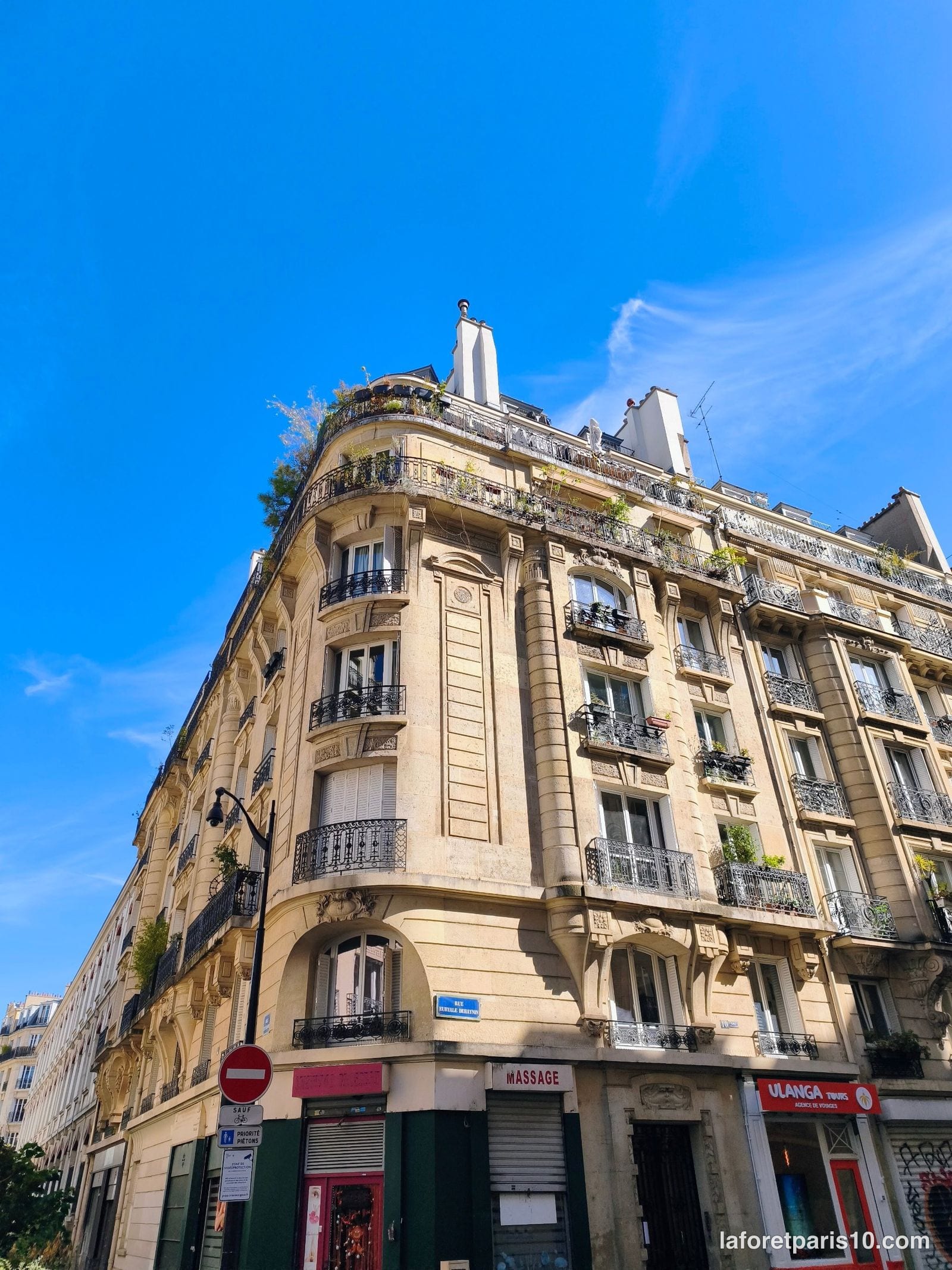 Angle arrondi du 10 rue Euryale-Dehaynin et de la rue Tandou, Paris 19e, avec commerces en rez-de-chaussée