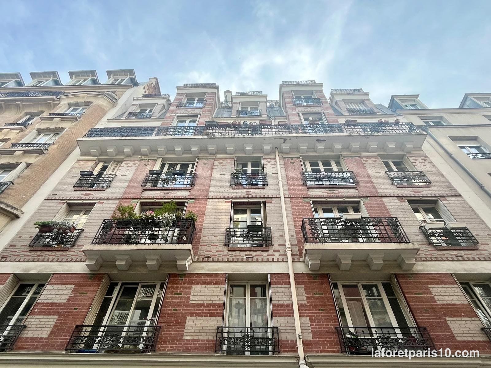 You are currently viewing 7bis rue de Lorraine, Paris 19e — immeuble en brique à balcons sur consoles