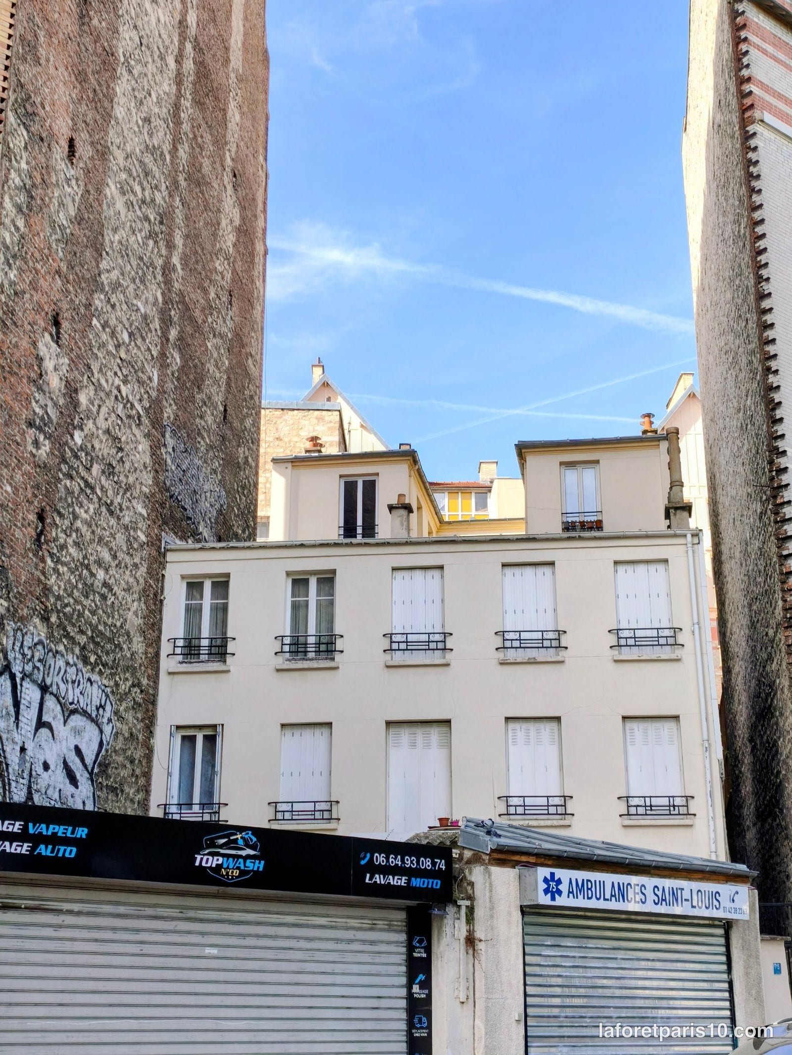Façade et commerces en rez-de-chaussée du 75 boulevard Sérurier, Paris 19e