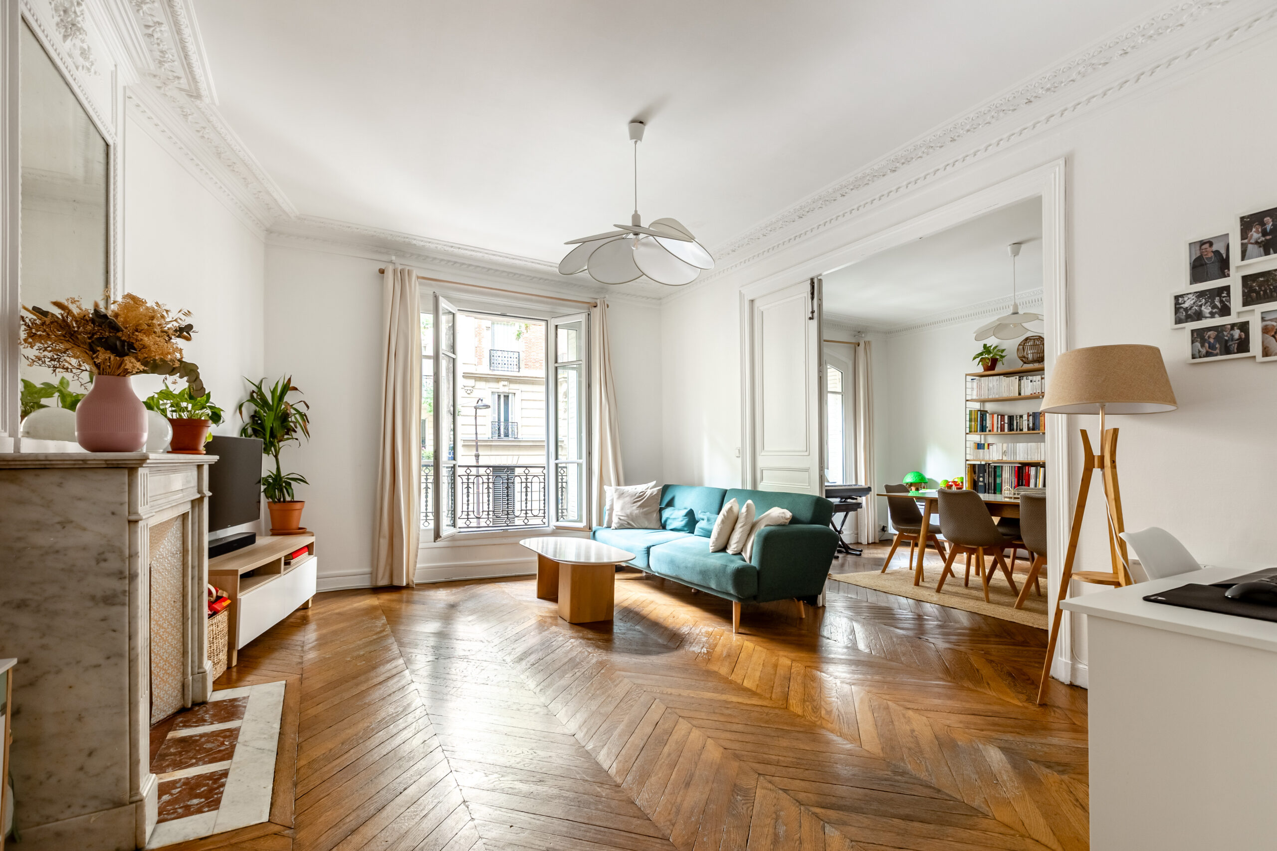 Double séjour d'un appartement 4 pièces 100,5 m², rue Caulaincourt, Paris 18e : parquet en point de Hongrie, cheminée en marbre, moulures et corniches, fenêtres sur rue exposées sud