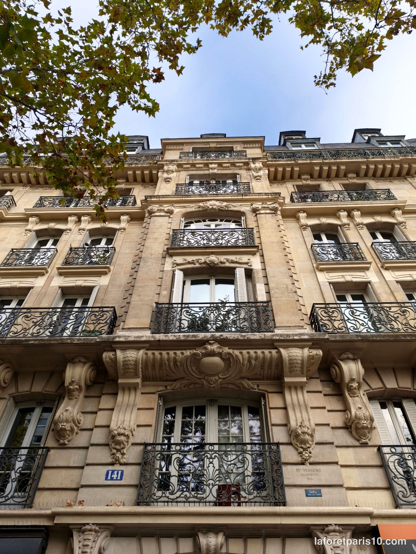 Consoles sculptées en volutes et cartouche au-dessus de l'entrée du 141 avenue Jean Jaurès, Paris 19e