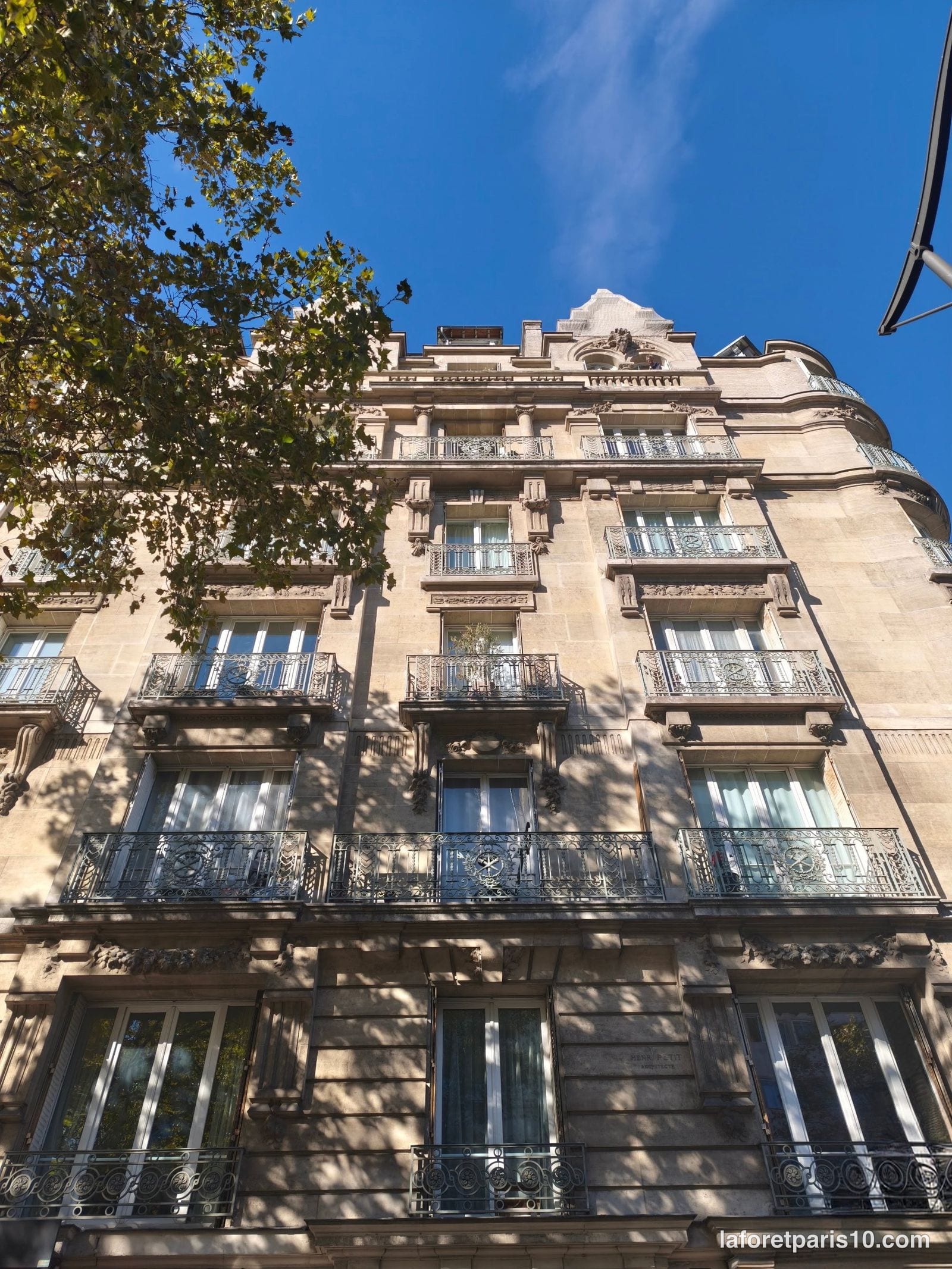 Façade sur avenue du 159 avenue Jean Jaurès, Paris 19e, avec balcons en fer forgé et lucarne sculptée