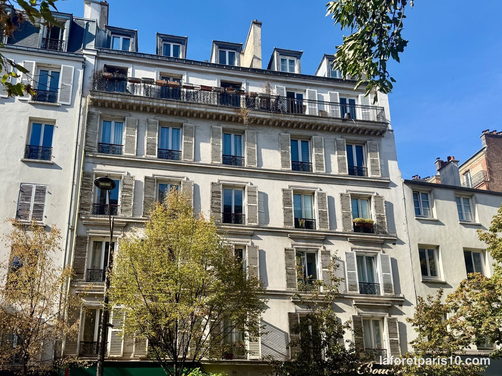 Façade du 205 rue du Faubourg Saint-Martin, Paris 10e, entre ses deux voisins, avec lucarnes et souches de cheminée