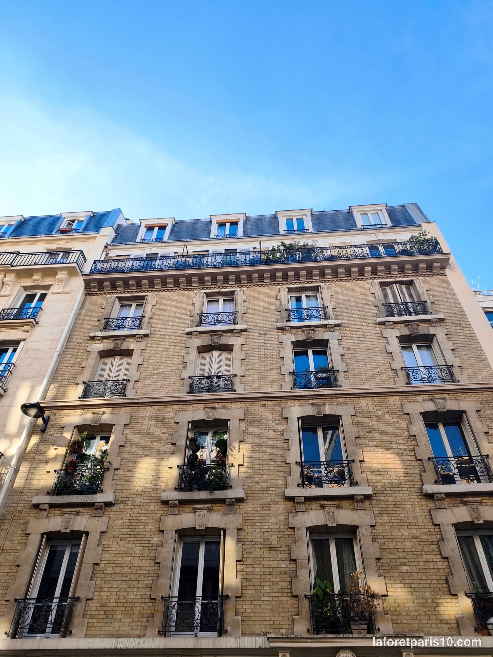 You are currently viewing 21 rue Cavendish, Paris 19e — immeuble de brique claire à balcon filant