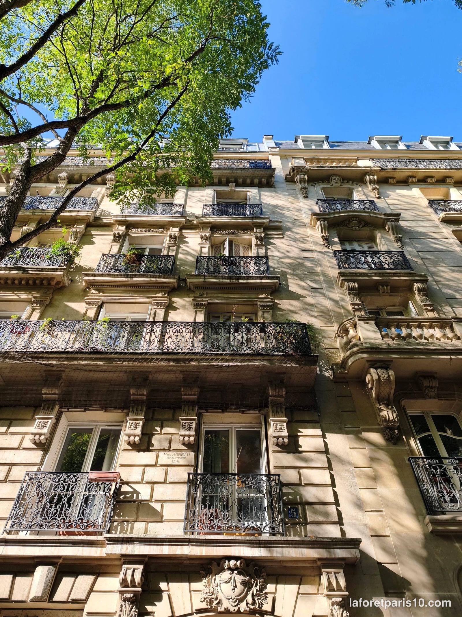 Façade en pierre de taille du 5 rue Meynadier, Paris 19e, à balcons filants en fer forgé